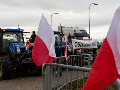 Polish flags are seen as farmers stand on a strike post as they block truck transport in M