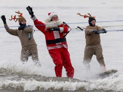 Men dressed as Santa Claus and his reindeer perform during the Water Skiing Santa Show in