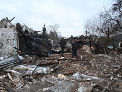 People stand among the debris of the destroyed Shukhevych Museum after a drone attack in B