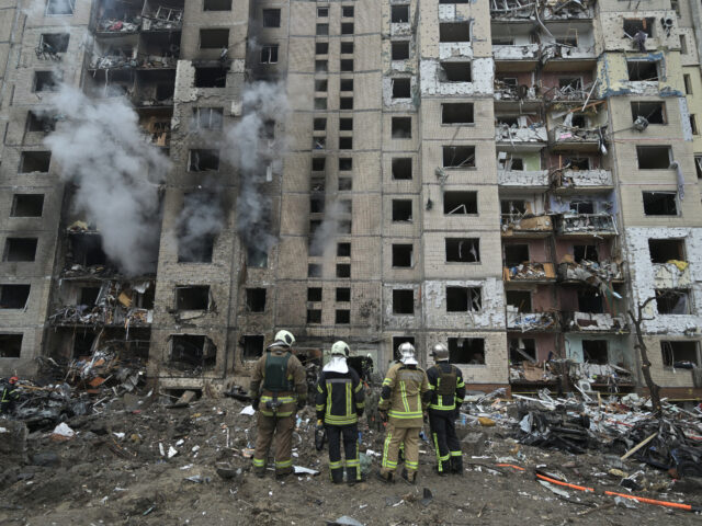 TOPSHOT - Firefighters work in a multi-storey residential building destroyed by a missile