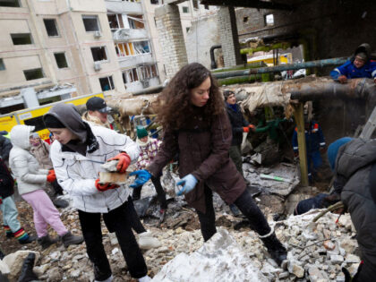 Residents are removing the rubble outside an apartment building in the Solomianskyi distri