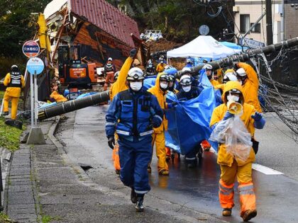Rescuers carry away the body of victim who was retrieved from a landslide site in the Kawa