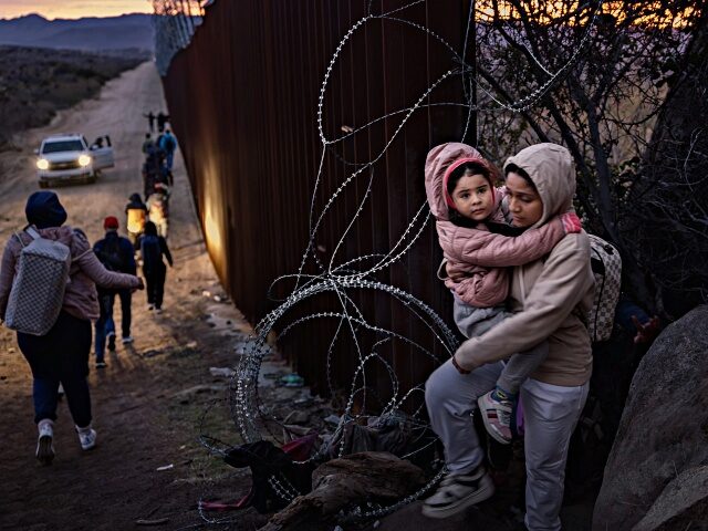 JACUMBA HOT SPRINGS, CALIFORNIA - JANUARY 03: Migrants cross through a gap in the US-Mexic