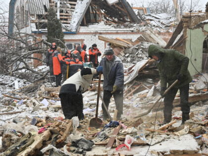 TOPSHOT - Rescuers and local residents clear debris following Russian strikes, in Zmiiv, K