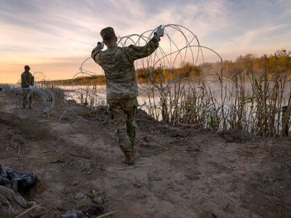 Texas National Guard soldiers install additional razor wire lie along the Rio Grande on Ja