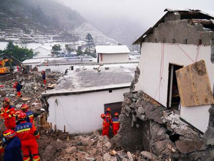 Rescue workers search for missing victims at a damaged house following a landslide in Lian