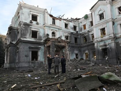 TOPSHOT - Local residents talk outside a heavily damaged building in Kharkiv on January 24