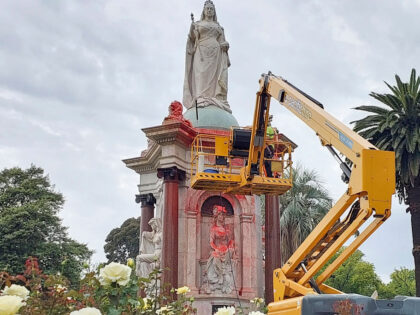 A council worker cleans the statue to Britain's Queen Victoria that was defaced in th