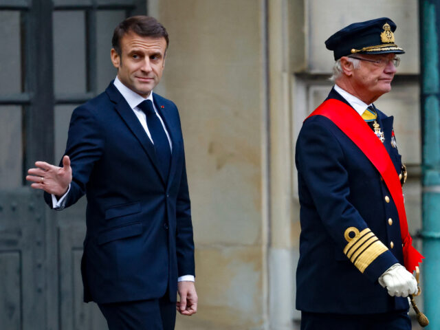 French President Emmanuel Macron (L), waves as he and King Carl XVI Gustaf of Sweden walks