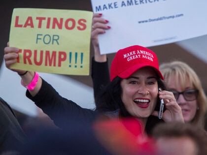 A woman hoods a sign expressing Latino support for Republican presidential candidate Donal