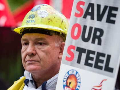 A steel worker holds a placard as he takes part in a protest march through central London