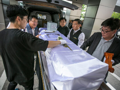 A volunteer Christian pastor (R), staff for Eunpyeong village funeral service, and staff f