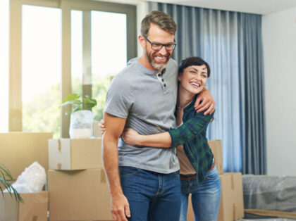 Shot of a happy couple embracing in their home on moving day