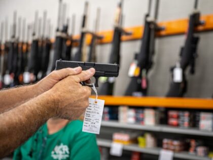 A customer holds a handgun for sale at Knob Creek Gun Range in West Point, Kentucky, U.S.,
