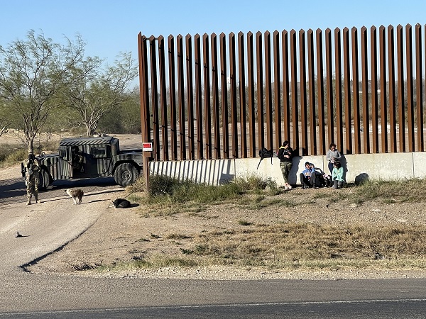 A Texas National Guard soldier detains a small group of migrants along the Texas-built border wall in Eagle Pass. (Randy Clark/Breitbart Texas)