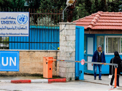 Palestinians stand at the entrance of the UNRWA-run University College for Educational Sci