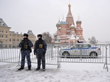 Police officers secure an area in front of Saint Basil's Cathedral on the snow-covere