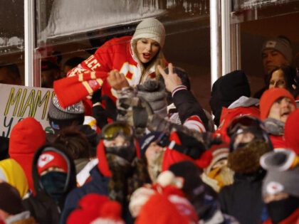 KANSAS CITY, MISSOURI - JANUARY 13: Taylor Swift celebrates with fans during the AFC Wild