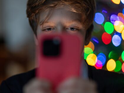 BATH, UNITED KINGDOM - DECEMBER 19: A 12-year-old boy looks at an iPhone screen on Decembe
