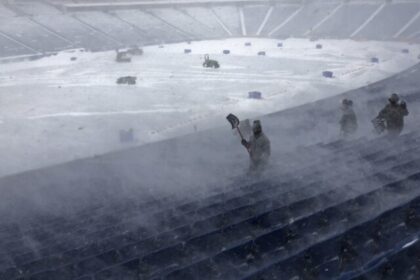 Workers remove snow from Highmark Stadium in Orchard Park, N.Y., Sunday Jan. 14, 2024. A p