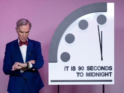 Science educator Bill Nye, looks at his watch next to the "Doomsday Clock," shortly before