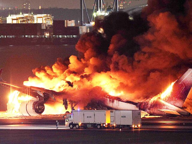 This photo provided by Jiji Press shows a Japan Airlines plane on fire on a runway of Toky