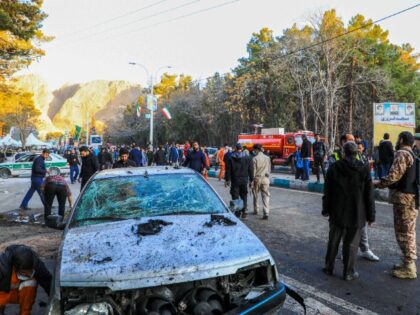 This picture shows people and Iranian emergency personnel at the site where two explosions