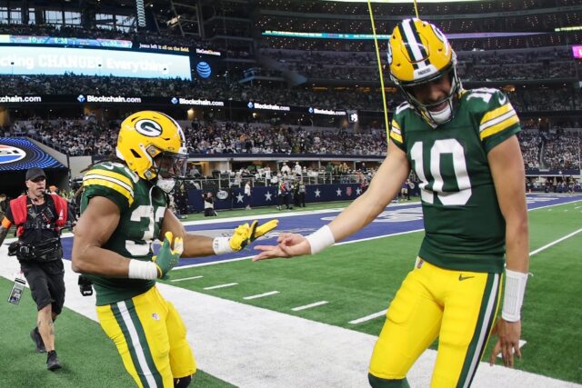 Aaron Jones (L) of the Green Bay Packers celebrates with quarterback Jordan Love following