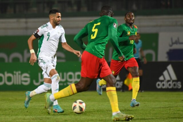 Algeria star Riyad Mahrez (L) attacks during a 2022 World Cup play-off against Cameroon in