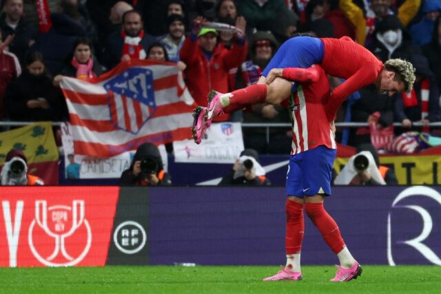 Atletico Madrid's French forward Antoine Griezmann is lifted by defender Jose Gimenez in c
