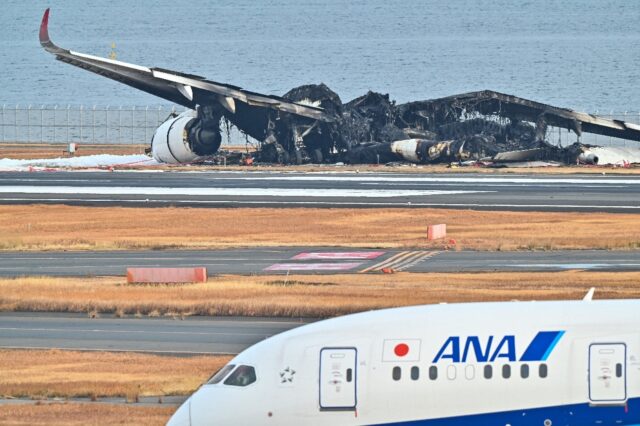 The burned-out wreckage of a Japan Airlines passenger plane sits on the tarmac at Tokyo's