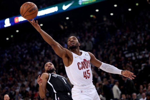 Cleveland guard Donovan Mitchell, right, leaps and scores in front of Brooklyn's Mikal Bri