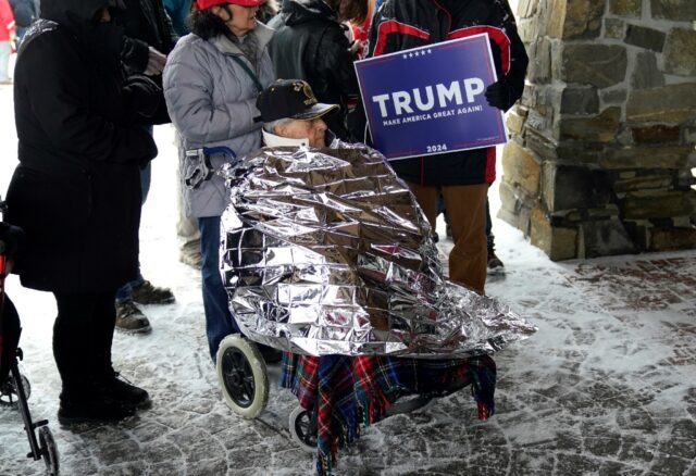 Donald Trump supporters bundle up in the winter cold waiting to attend rally for the Repub