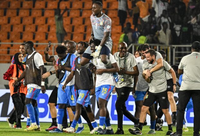 DR Congo goalkeeper Lionel Mpasi is held aloft by his teammates after scoring the winning