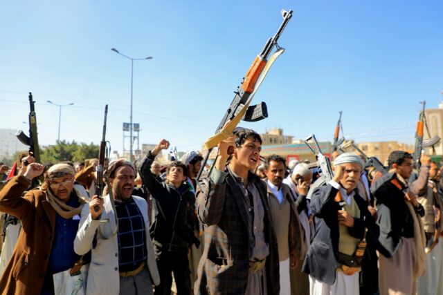 Huthi fighters brandish their weapons during a march in solidarity with the Palestinian pe