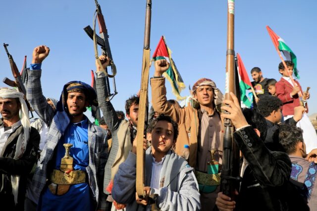 Huthi fighters brandish weapons during a protest in Sanaa on January 12, 2024 following US