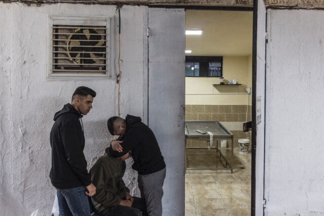 Mourners gather at the morgue where the body of Yamen Mohammed Husseti, 16, was laid ahead