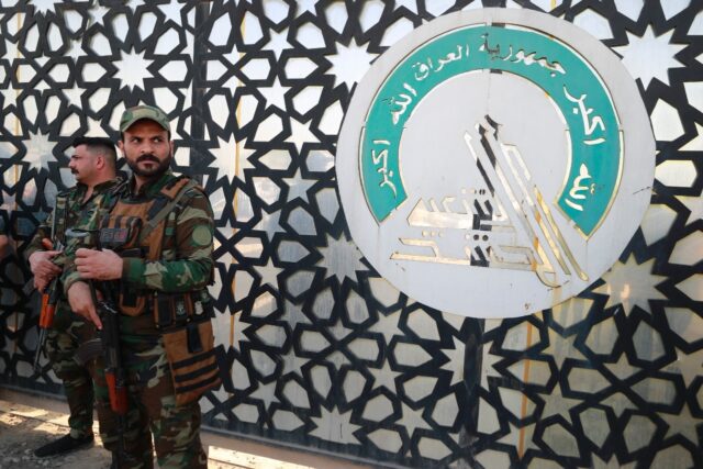 Members of Iraq's Hashed al-Shaabi stand guard at the entrance of their headquarters in Ba