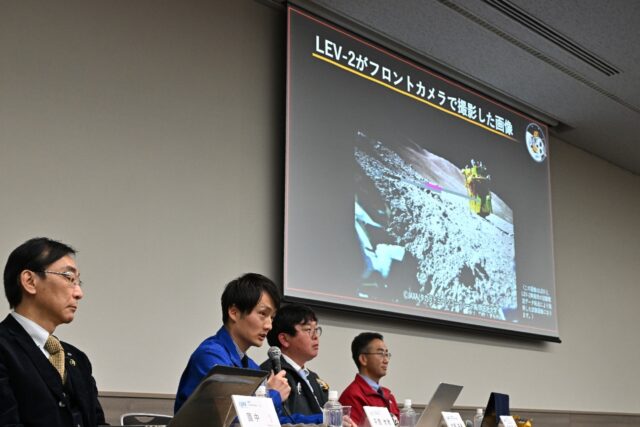 Members of the Japanese space agency JAXA explain an image of the lunar surface taken and