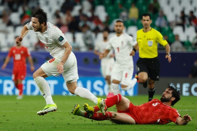 Palestine's defender #05 Mohammed Saleh tackles Iran's forward #20 Sardar Azmoun during th