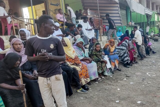 People from states of Khartoum and al-Jazira, displaced by the ongoing conflict in Sudan between the army and paramilitaries, wait to receive aid from a charity organisation in Gedaref on December 30, 2023