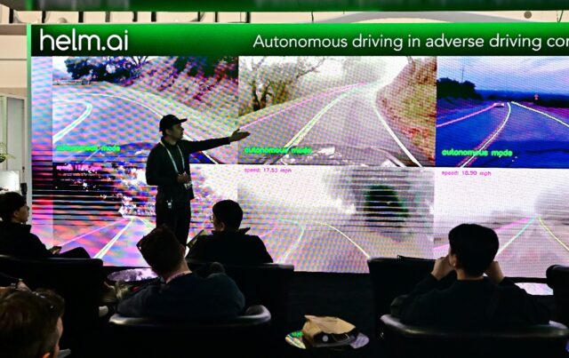 People sample an autonomous driving experience from Helm.ai during a display at the Consum