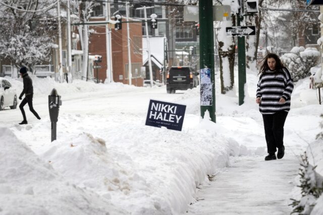 Residents walk by a campaign sing for 2024 presidential hopeful Nikki Haley in Iowa City,