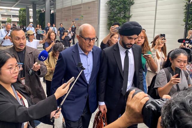 Singaporean transport minister S. Iswaran (centre L) leaves court after an appearance on T