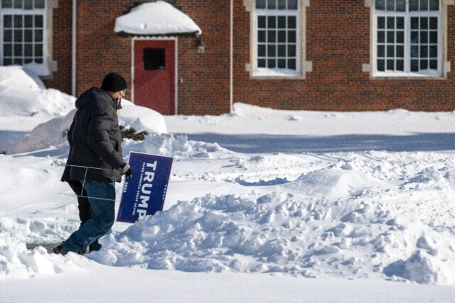 Supporters of former US president and 2024 presidential hopeful Donald Trump carry placard