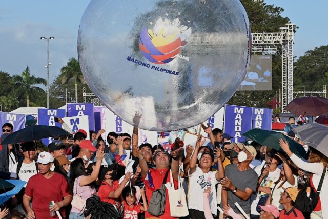 Thousands of flag-waving people massed at a seaside park in the capital Manila hours ahead