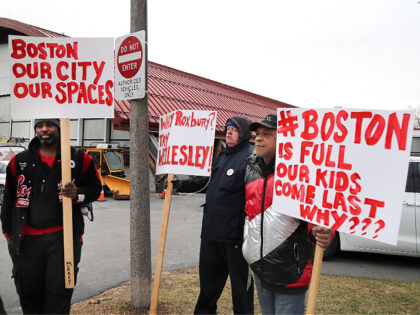 Boston, MA - January 31: Protesters hold signs outside as State and local officials toured