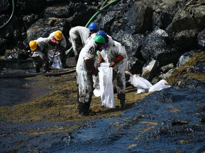 Workers from state own Heritage Petroleum Oil and Gas Company clean up an oil spill that r