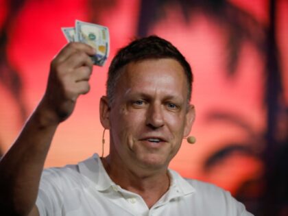 Peter Thiel, president and founder of Clarium Capital Management LLC, holds hundred dollar