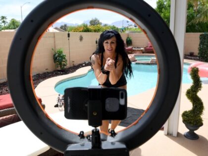 Entertainer Jennifer Romas, shown through a ring light, records a tutorial in her backyard